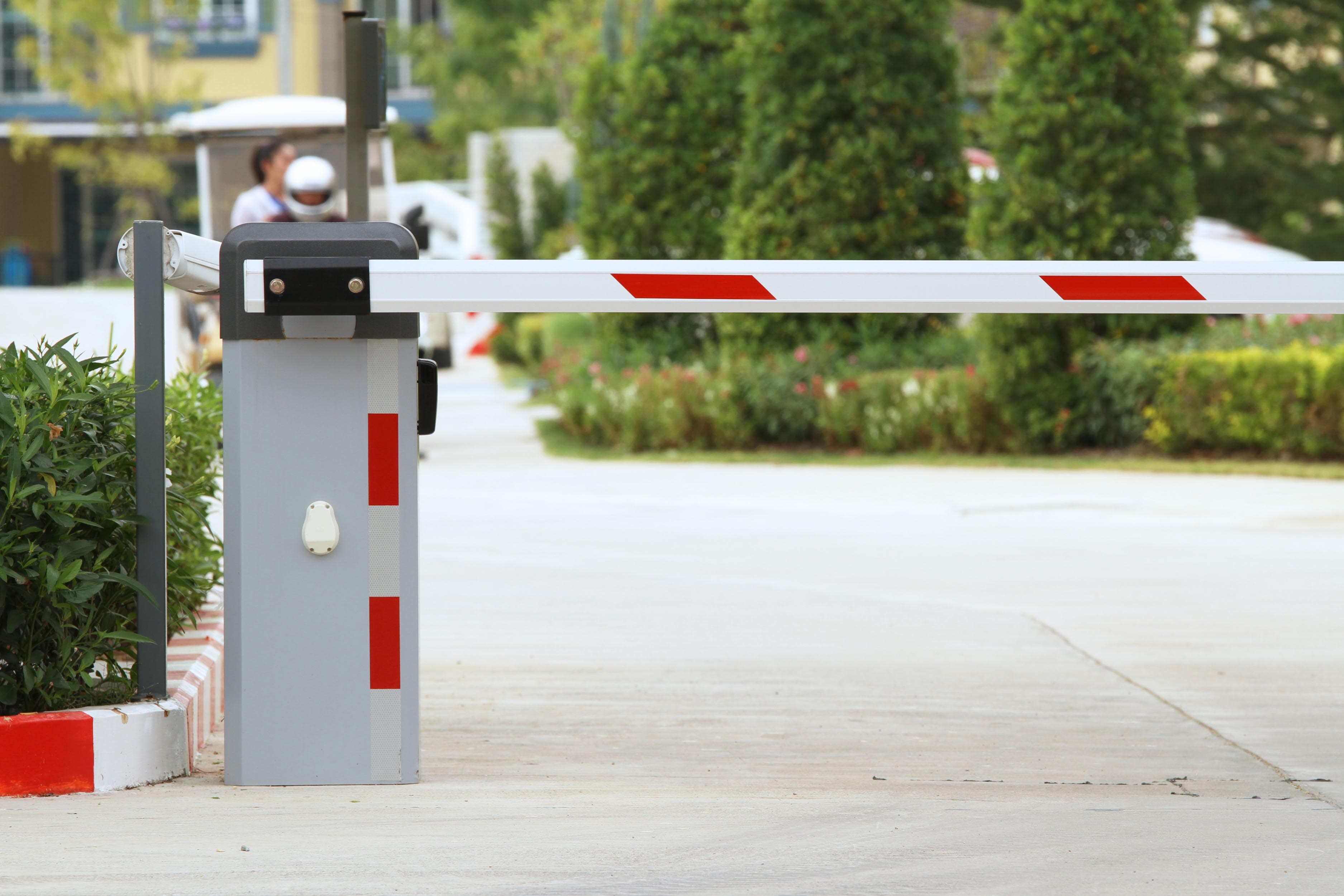 Automatic boom barrier with its arm across a controlled vehicle entry lane